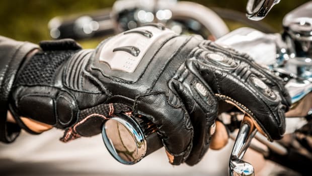 Ein Motorradfahrer mit Motorradhandschuh am Lenker