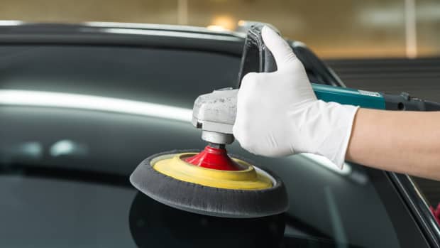 Scheibe eines Autos wir mit einer Poliermaschine bearbeitet