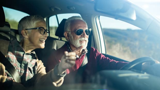 Seniorenpaar fährt in einem Auto, der Mann am Steuer