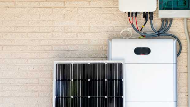 Vorderansicht des Photovoltaik-Panels und der Batterieanlage, die an der beige-weißen Wand lehnt