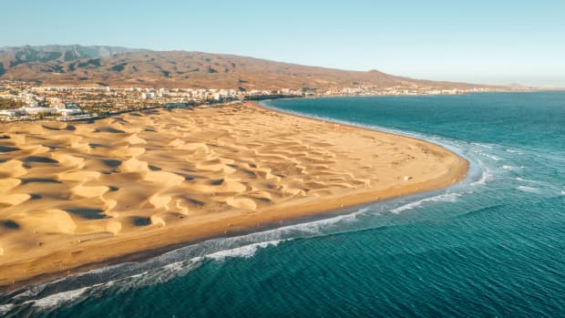 Drohnenaufnahme mit Dünen, Meer und Maspalomas im Hintergrund