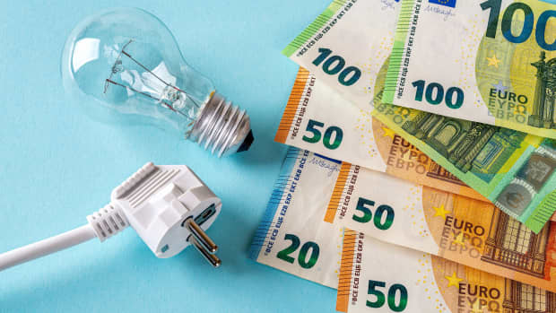 Stecker, Glühbirne und Geldscheine