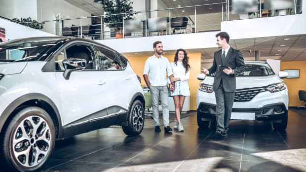 Autohändler berät Paar bei Autokauf