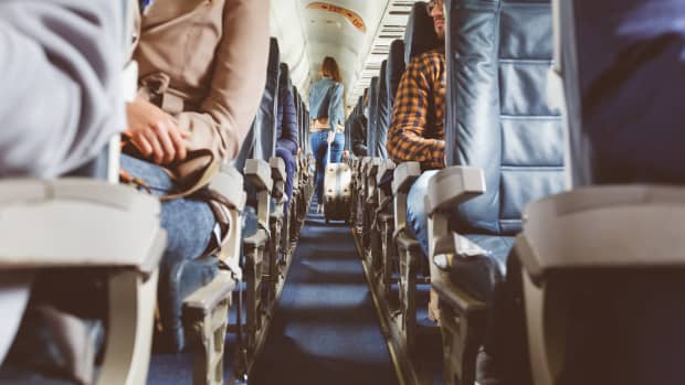 junge Frau im Gang eines Flugzeugs