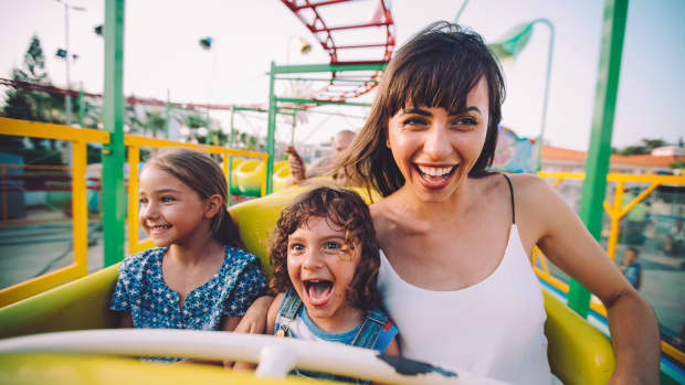 Frau fährt mit Kindern in der Achterbahn