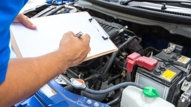 Ein Mechaniker untersucht ein Auto in einer Werkstatt