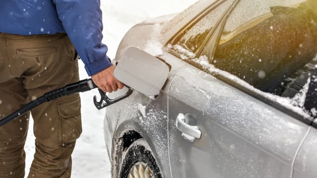 Mann tankt Auto im Winter