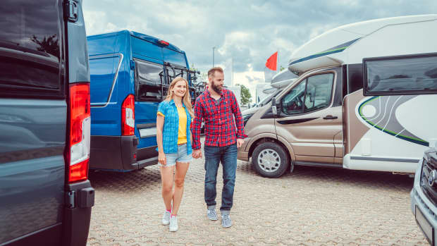 Junges Paar sieht sich Wohnmobile an, die zum Verkauf stehen