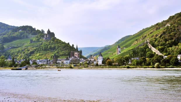 Blick über den Rhein auf Bad Bacherach im Sommer mit Stadtmauer und Burg Stahleck
