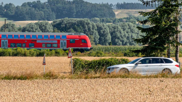 Ein Auto und ein Regionalexpress fahren nebeneinander