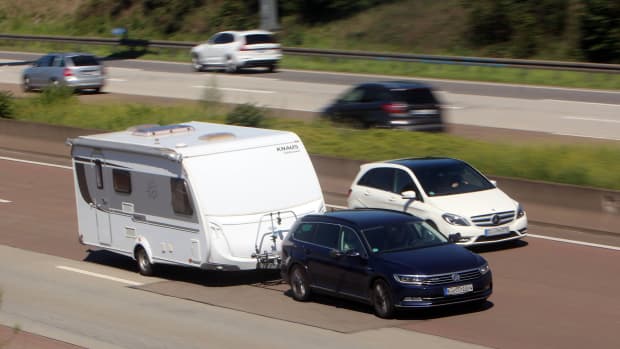 Auto fährt mit Wohnanhänger auf Autobahn