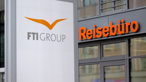 Das Firmenloge oder FTI Group vor einem Reisebüro
