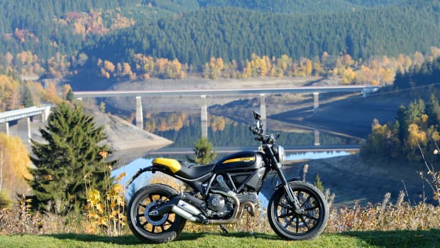 Ein Motorrad steht vor einem See bei Schulenberg im Harz