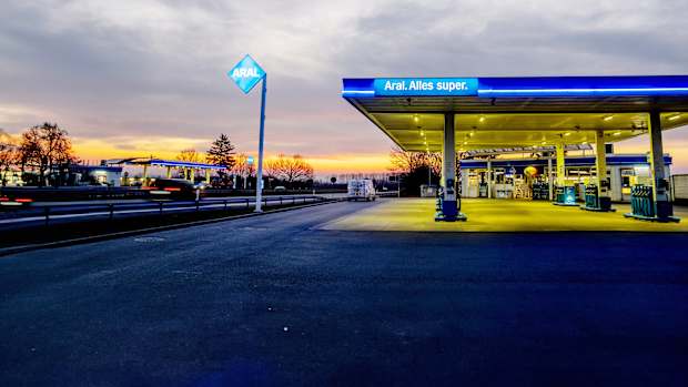 Aufnahme einer Araltankstelle bei Dämmerung an der Autobahn