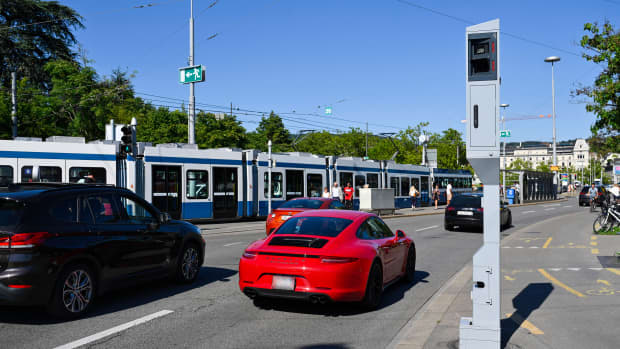 Roter Porsche fährt an einem Blitzer in der Innenstadt von Zürich vorbei