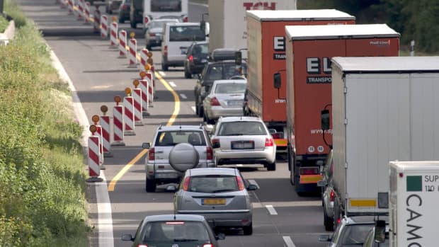 Autos wenden Reißverschlussverfahren in einer Baustelle an