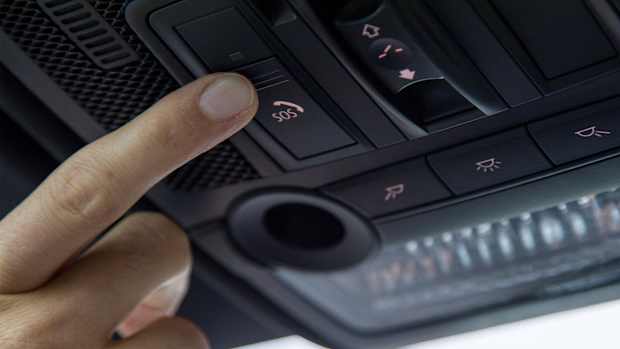 Clopse up Aufnahme eines Fingers, welcher den SOS Knopf im Auto betätigt.