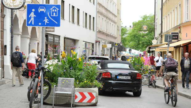 Eine Spielstra�ße mit Autos, Radfahrern und Fußgängern