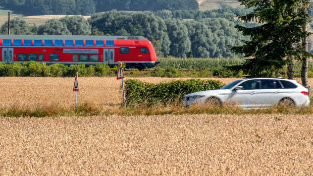 Ein Auto und ein Regionalexpress fahren nebeneinander