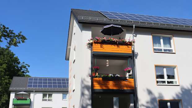 Ein Mehrfamilienhaus mit Solarpaneelen auf dem Dach