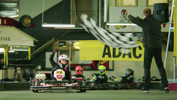 Kind fährt bei einem Rennen auf der Kartbahn über die Ziellinie