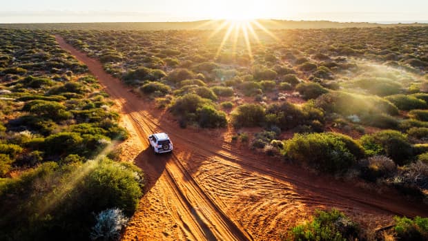 Ein Auto fährt durch das Gelände in Südafrika