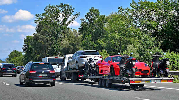 Gebrauchte Fahrzeuge werden auf einem Autohänger ins Ausland überführt