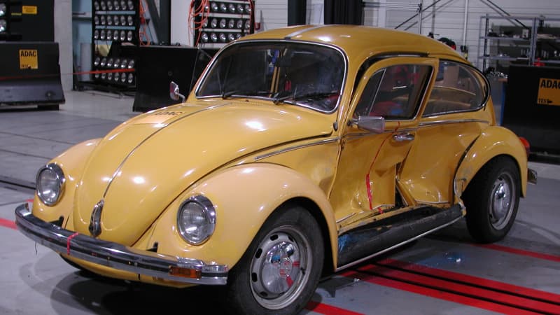 Ein gelber VW Käfer Baujahr 1983 nach einem Crashtest mit eingedellten Türe