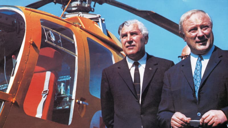 Zwei Männer stehen an einem Hubschrauber