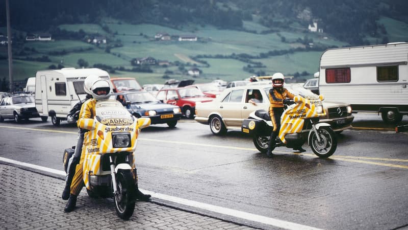 Zwei Stauberater fahren mit ihren Motorrädern in einem Stau auf der Autobahn