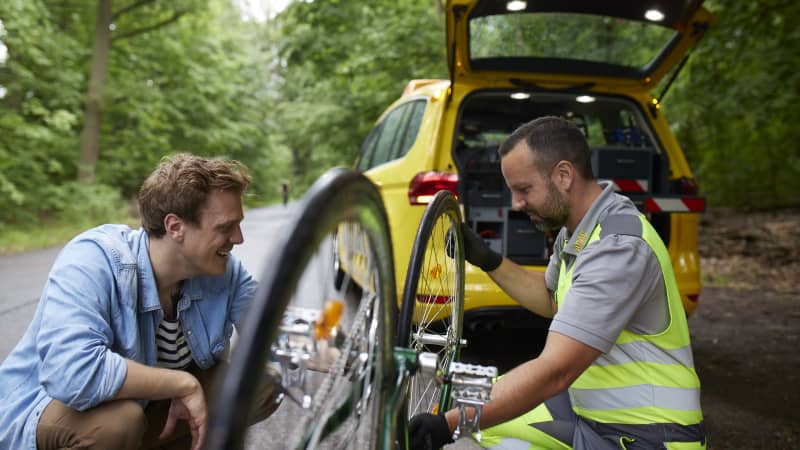 ADAC Pannenhelfer hilft einem Mann mit Fahrradpanne