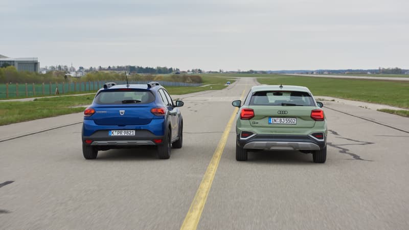 Vergleichstest vom Audi Q2 und Dacia Sandero, beide Autos von hinten nebeneinander fahrend.