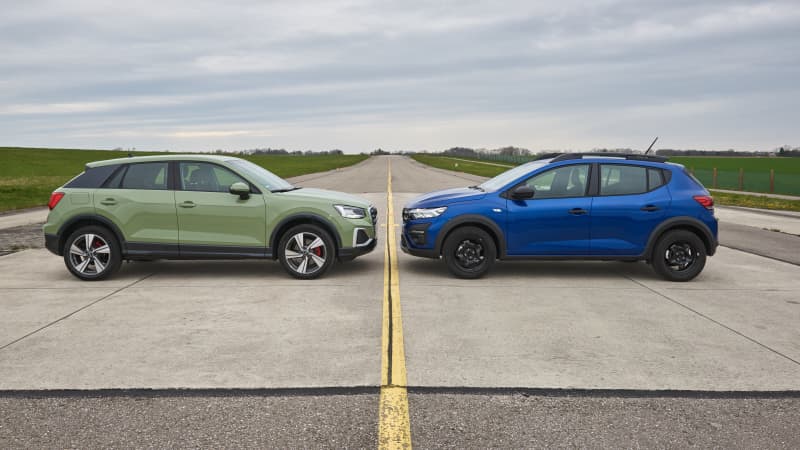 Beim Vergleichstest von Audi Q2 und Dacia Sandero stehen sich beide Autos auf einer Rollbahn gegenüber