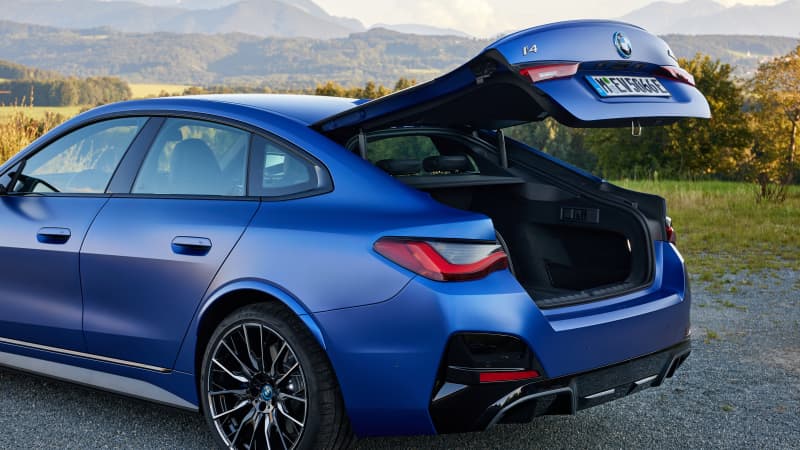 Der geöffnete Kofferraum des neuen blauen BMW i40 M50 mit Autokennzeichen