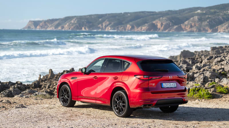 Ein roter Mazda CX 60 parkend, von hinten zu sehen an einer Steilküste