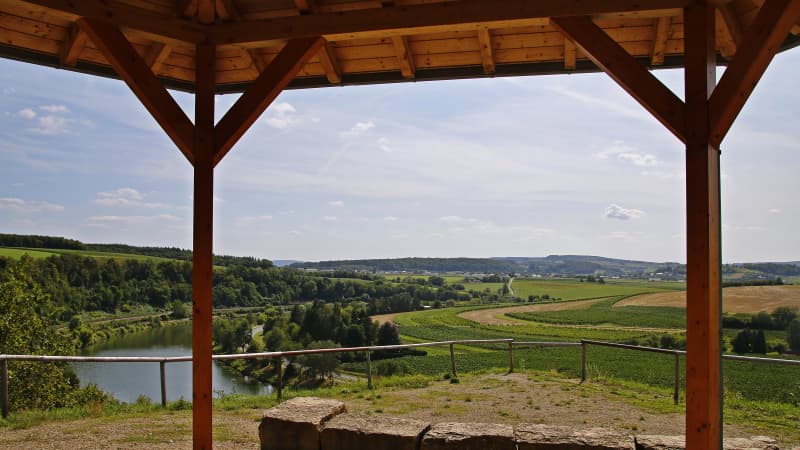 Blick aus einem Holzpavillon auf eine Landschaft mit Fluss