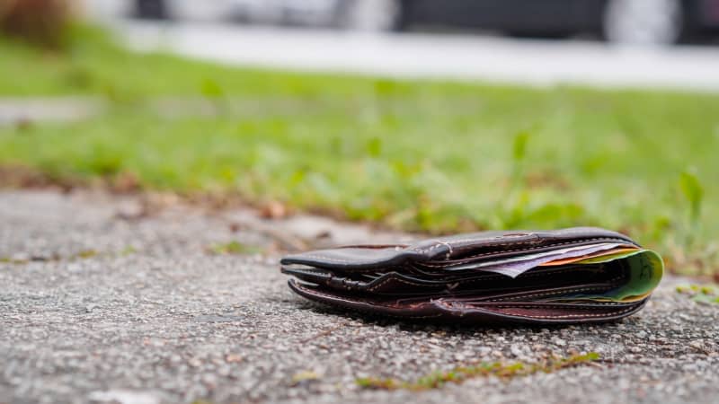 Eine mit Geld gefüllte Geldbörse liegt verloren auf der Strasse
