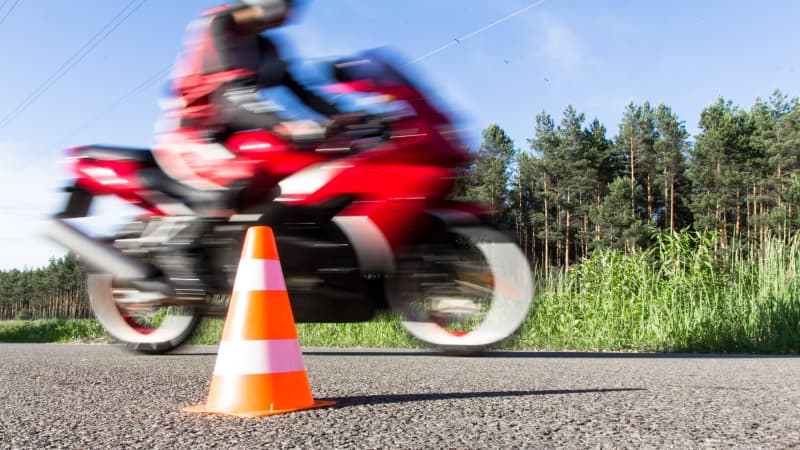 Fahrer auf rotem Motorrad bei Fahrübungen mit einer Pylone