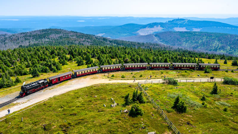 Ein Zug fährt durch eine Berglandschaft.