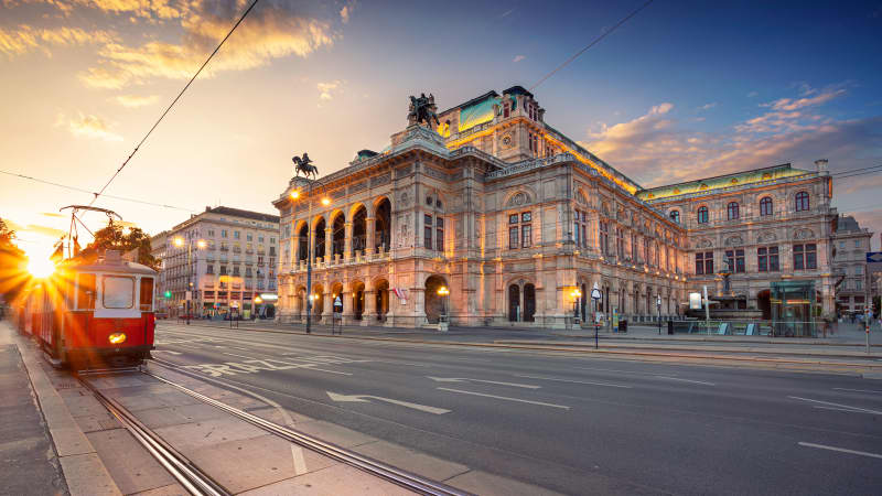 Eine Straßenbahn fährt an der Oper in Wien vorbei.