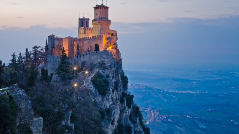 Eine Burg in San Marino auf dem Berggipfel im Abendlicht