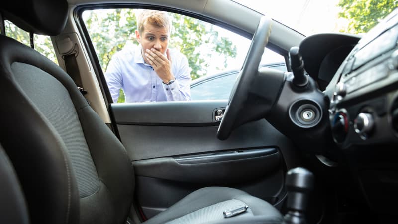 Ein Mann steht verzweifelt vor seinem verschlossenem Auto