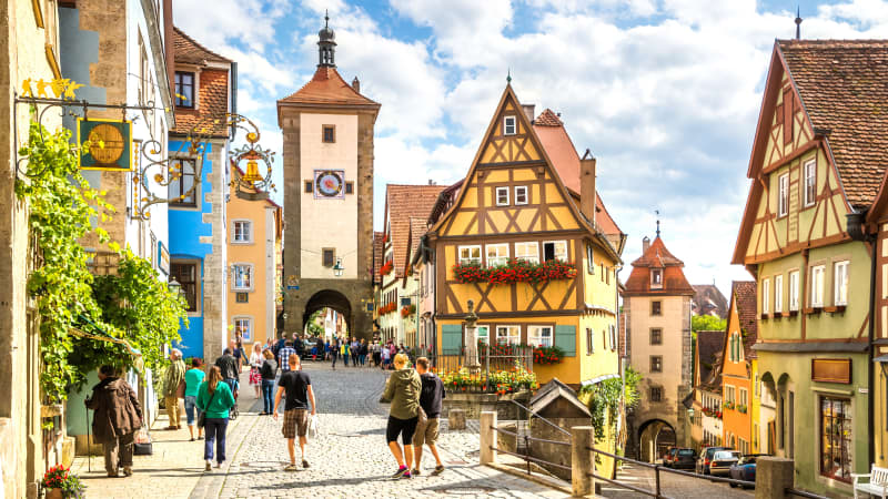 Touristen am Stadtturm in der mittelalterlichen Altstadt von Rothenburg ob der Tauber mit ihren bunten Fachwerkhäusern