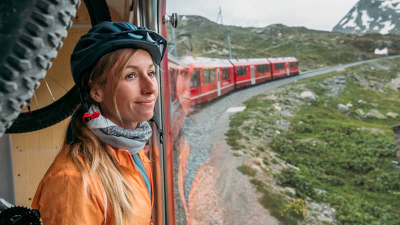 Junge Frau, die mit dem Zug in der Schweiz reist.