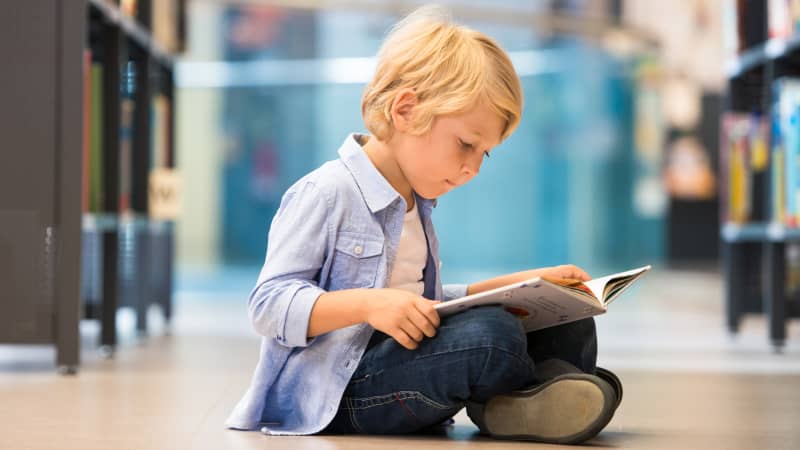 kleiner Junge liest in einem Buch