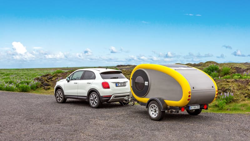 Ein kleiner weisser Fiat mit einem kleinen Caravan-Anhänger