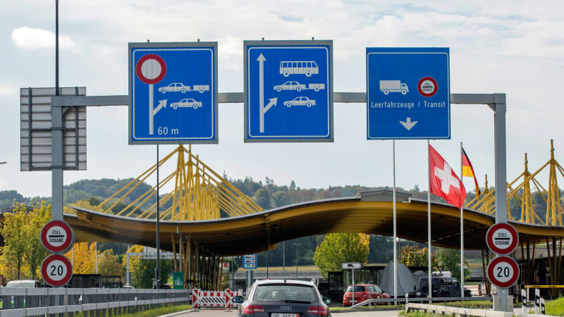 Rückansicht eines schwarzen Audis mit Ausfuhrkennzeichen der auf die einen schweizer Grenzkontrollposten zufährt