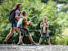 Eine Mutter mit ihren 2 Kindern auf einer Wanderung durch den Wald