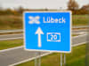 Ein blaues Straßenschild an einer Autobahn dass das Autobahnkreuz Lübeck anzeigt