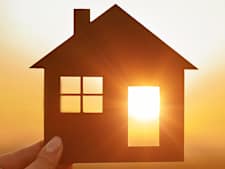 Silhouette eines Hauses, durch dessen offene Tür und Fenster die Sonne scheint, um zu zeigen, dass die Verbindung Photovoltaik E-Auto gut funktioniert.